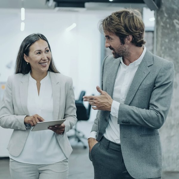 Two senior managers in discussion walking through an office